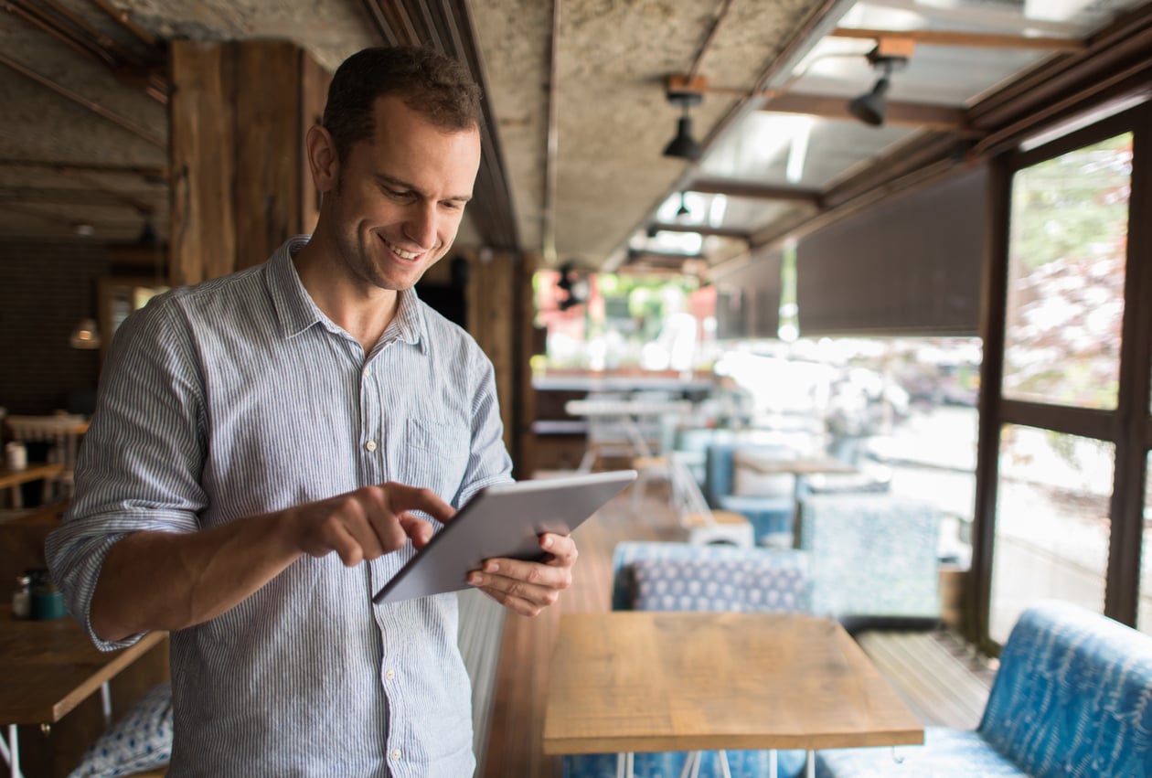 Man in restaurant holding tablet