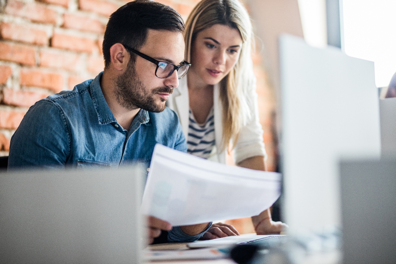 man_and_woman_looking_at_list_and_computer