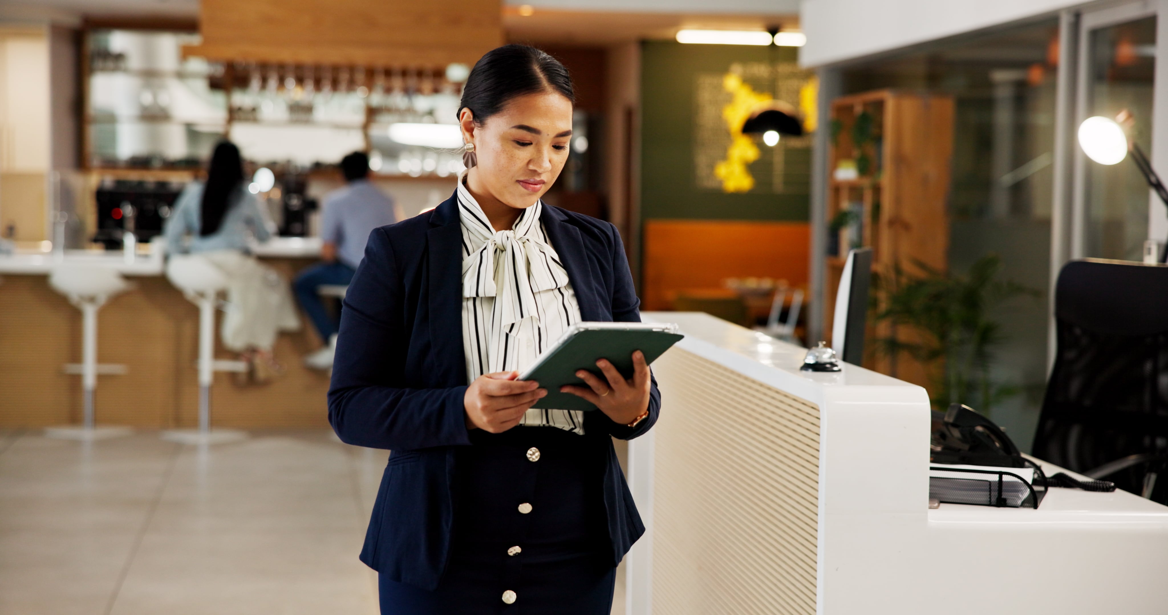 Women in hotel lobby holding tablet